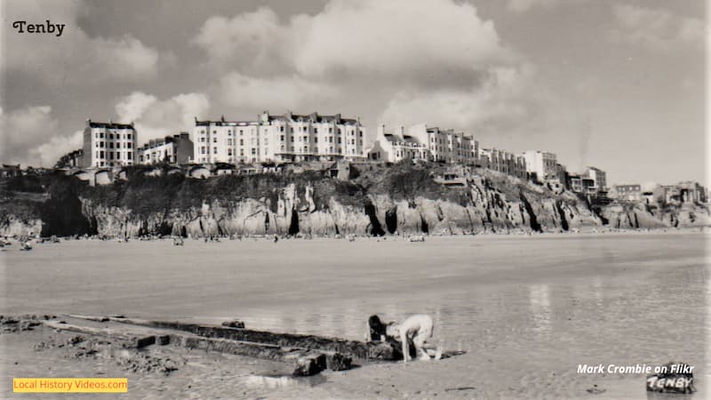 old back and white photo of children playing on the beach at Tenby
