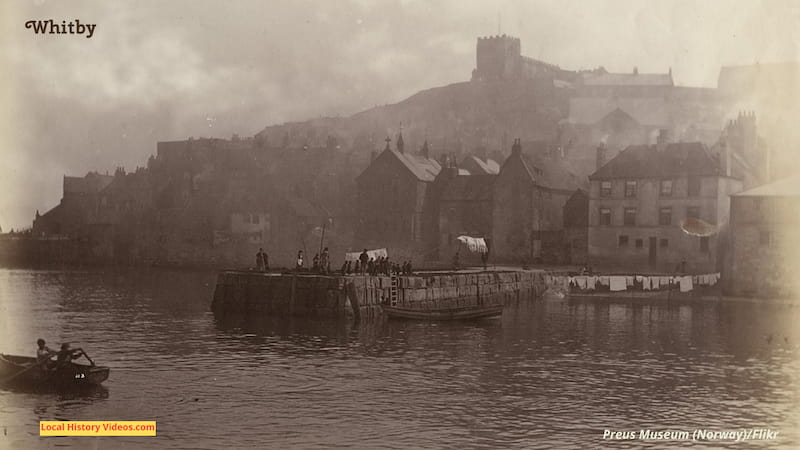 Old photo of the pier at Whitby with boats and washing