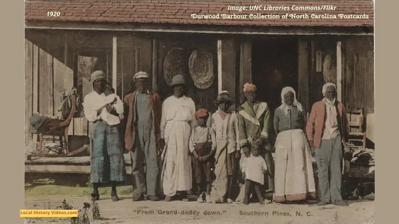 Old postcard of a three generation African-American family outside their wooden cabin in Southern Pines, North Carolina