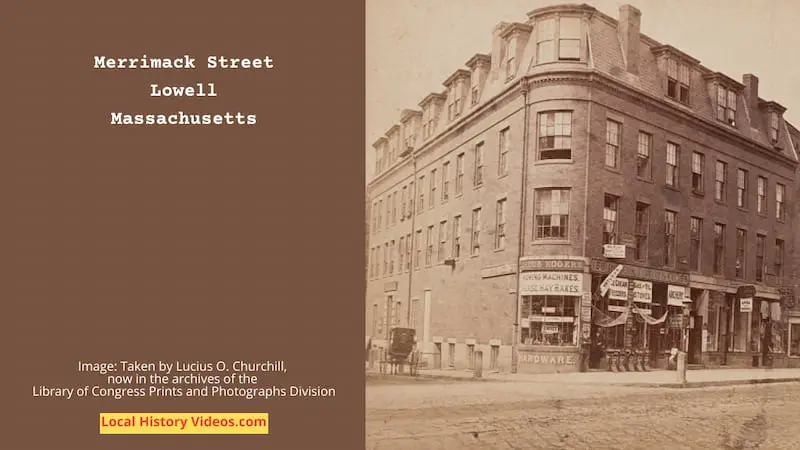 Old photo of a building and shops in Merrimack Street, Lowell, MA