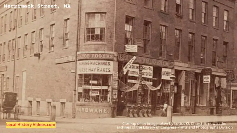 Closeup of an old photo of a building and shops in Merrimack Street, Lowell, MA