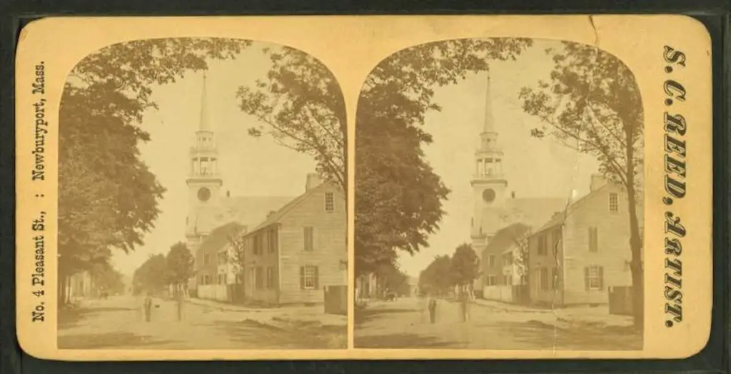 Old stereograph image of a view of people standing on a commercial street in Newburyport, church visible in background