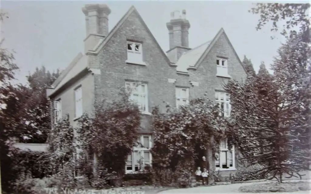 Vintage postcard of the Vicarage at Marsworth, Buckinghamshire, with the vicar and two boys standing at the front door