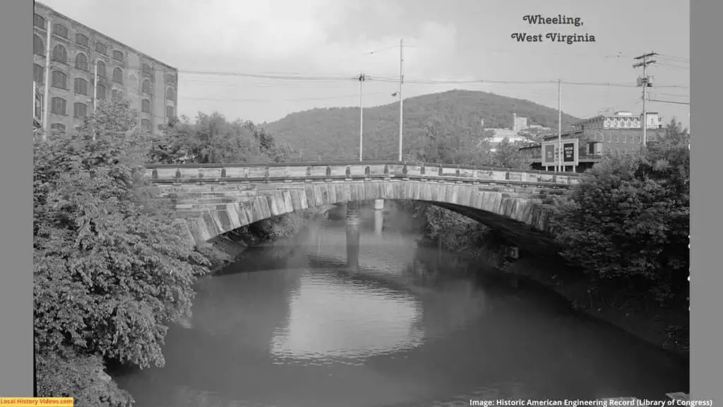 Old photo of a small bridge and nearby buildings at Wheeling, West Virginia