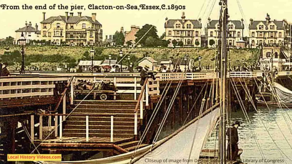 Closeup of seafront properties in an old photo of boats at the end of the pier at Clacton-on-Sea, Essex, in the 1890s